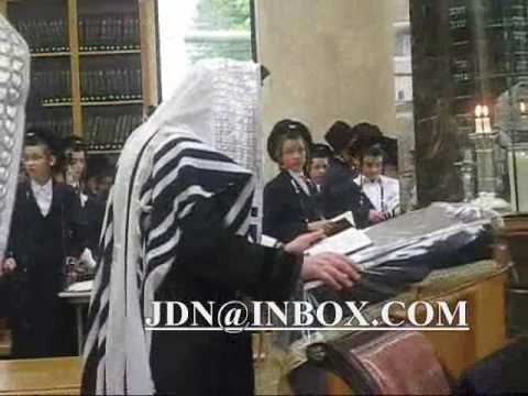 MD Unger putting on tefilin on barmitzvah boy